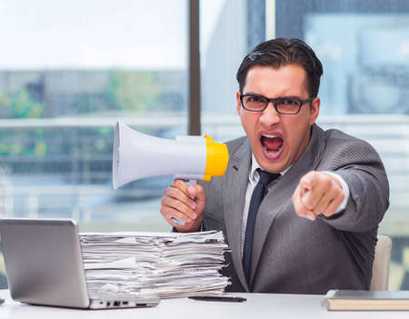 The angry businessman with loudspeaker in the officeの写真素材