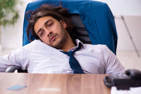 Drug addicted male employee working in the officeの写真素材