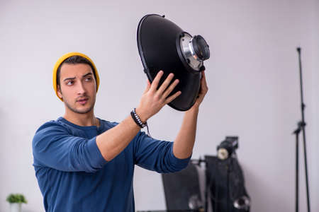 Young male photographer working in the studioの写真素材