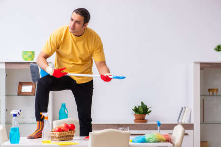Young male contractor cleaning the house