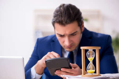 Young male employee in time management concept