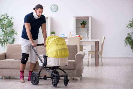 Young man after accident looking after newbornの写真素材