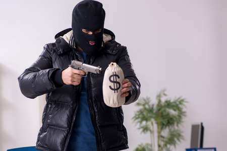 Young male burglar in the officeの写真素材