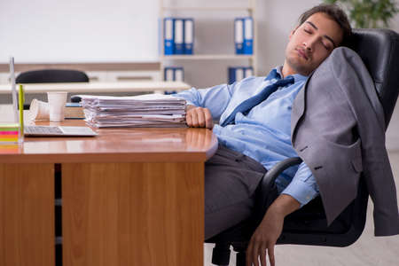 Young male employee sleeping in the officeの写真素材
