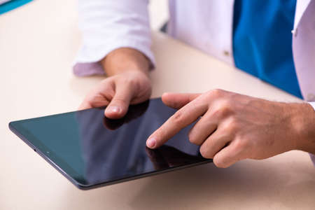 Young male doctor in telemedicine conceptの写真素材