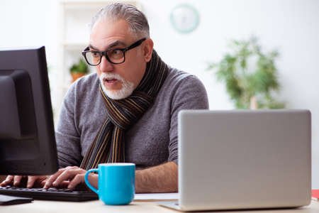 Old male employee working from house during pandemic