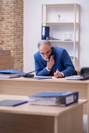 Old male boss employee working in the officeの写真素材