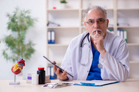 Old male doctor in telehealth concept