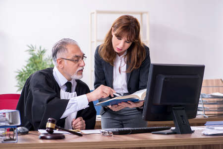 Old male judge and his young secretary in the office