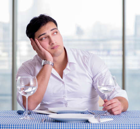 Handsome man alone in restaraunt on dateの写真素材