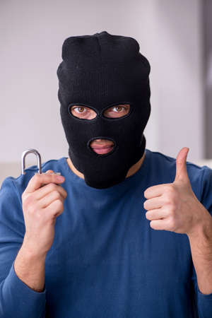 Male robber stealing valuable things from the houseの写真素材