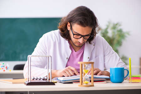 Young male physicist teacher in time management conceptの写真素材