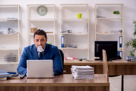 Young male employee unhappy with excessive workの写真素材