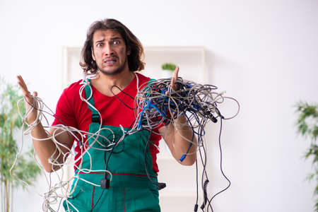 Funny young male electrician working indoors