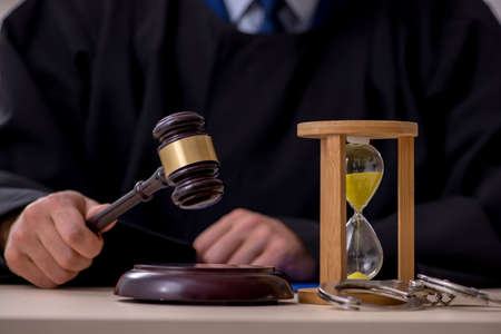 Young male judge in time management conceptの写真素材