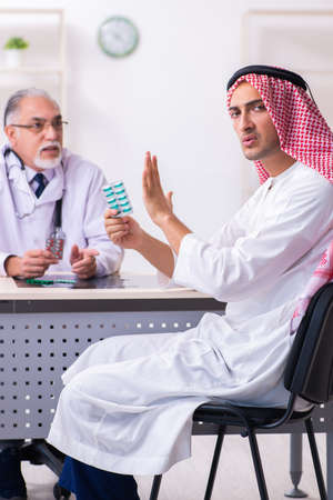 Young male arab visiting experienced male doctorの写真素材