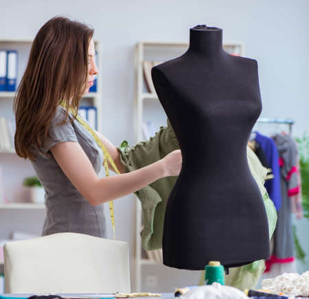 Woman tailor working on a clothing sewing stitching measuring faの写真素材