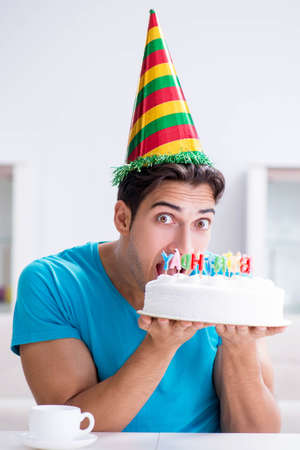 Young man celebrating birthday alone at homeの写真素材