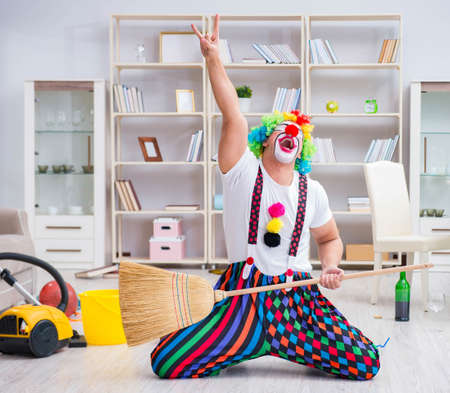 Funny clown doing cleaning at homeの写真素材