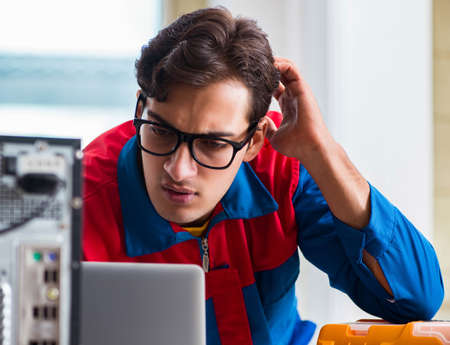 Computer repairman working on repairing computer in IT workshopの写真素材