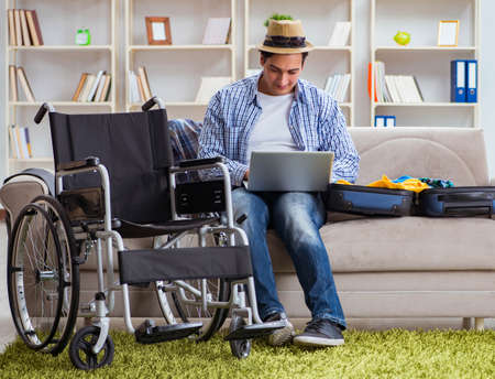 Disabled man booking travel online using laptop computerの写真素材