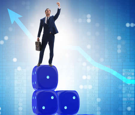 Businessman balancing on top of dice stack in uncertainty concepの写真素材