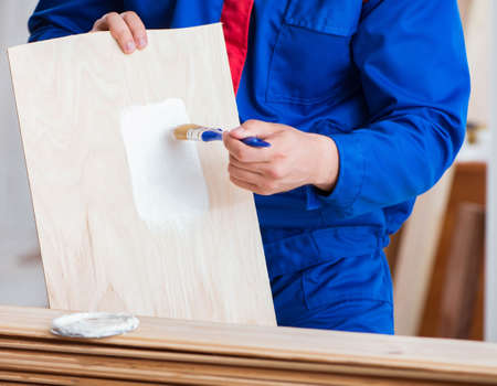 The yooung repairman carpenter working with paint paintingの写真素材