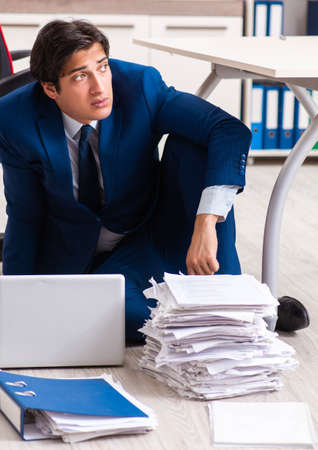 Tired exhausted businessman working overtime in officeの写真素材