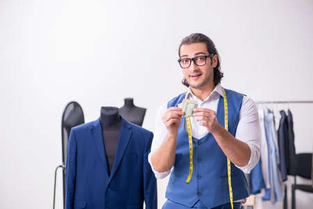 Young male tailor working at workshop