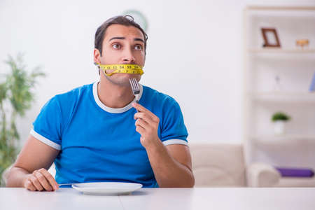 Young hungry man in dieting conceptの写真素材