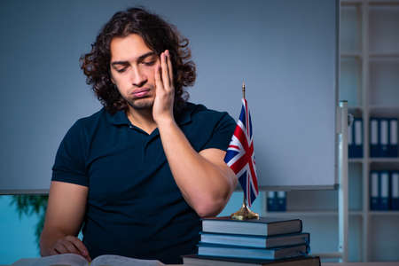 Young male student in the classroom at nightの写真素材