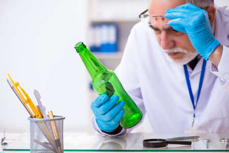 Old male expert criminologist working in the lab for evidenceの写真素材