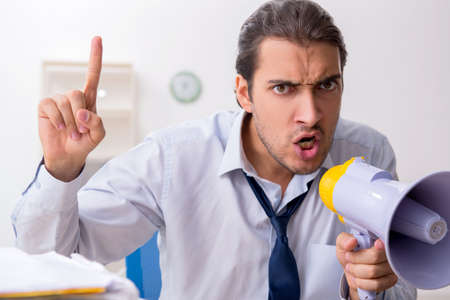 Young male businessman employee unhappy with excessive workの写真素材