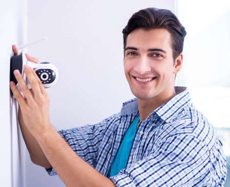 Man installing surveillance CCTV cameras at homeの写真素材