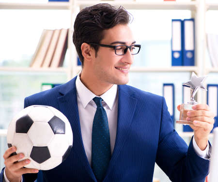 Businessman playing football in the officeの写真素材