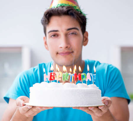 Young man celebrating birthday alone at homeの写真素材