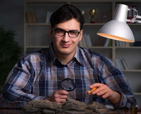 Archeologist working late night in office