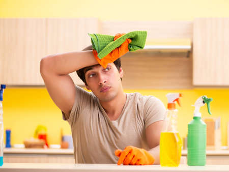 Single man cleaning kitchen at homeの写真素材