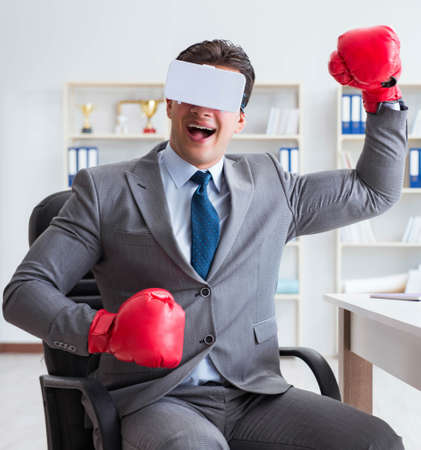 Man boxing in the office with virtual reality gogglesの写真素材