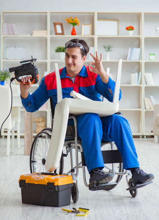 Disabled man repairing chair in workshopの写真素材