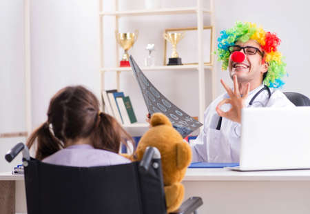 Funny pediatrician with little girl at regular check-upの写真素材