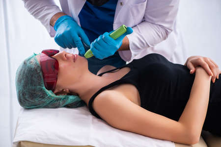 Young woman visiting male doctor dermatologist