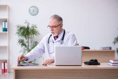 Old male doctor radiologist working in the clinicの写真素材