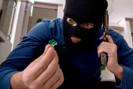 Male robber stealing valuable things from the houseの写真素材