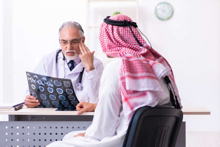 Young male arab visiting experienced male doctorの写真素材
