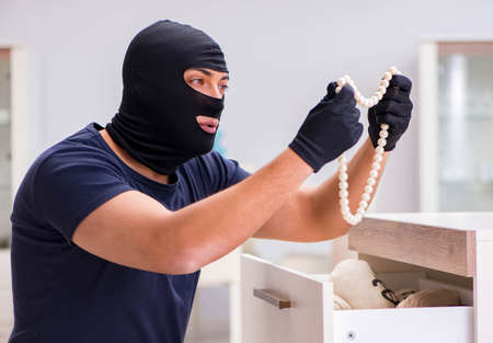 Robber wearing balaclava stealing valuable thingsの写真素材