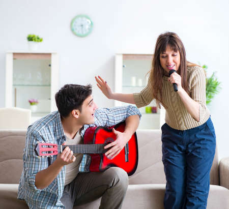 Young family singing and playing music at homeの写真素材