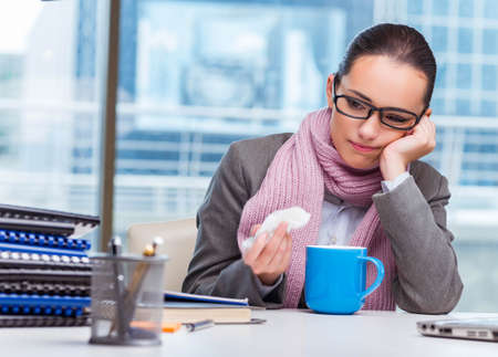 Young businesswoman sick in the officeの写真素材