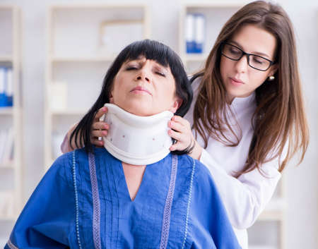 Senior woman with neck injury at doctorsの写真素材
