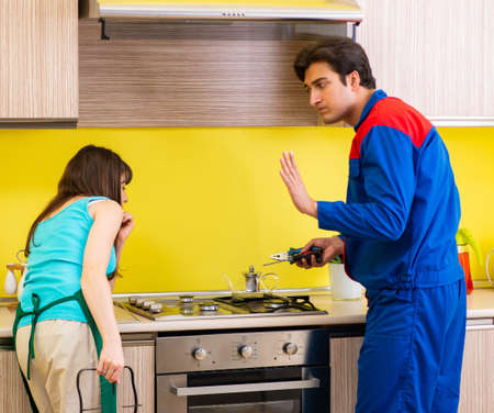 Woman with contractor at kitchen discussing repairの写真素材